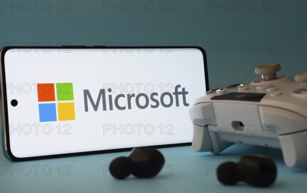 Dhaka, Bangladesh- 23 Mar 2025: A smartphone with a Microsoft icon next to a controller and earbuds