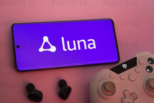 Dhaka, Bangladesh- 22 Mar 2025: Smartphone with Amazon Luna logo, game controller, and earbuds on a