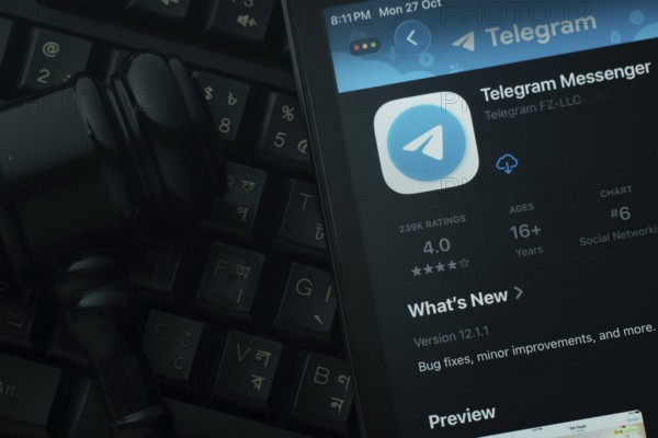 Dhaka, Bangladesh- 28 Oct 2025: An iPad displaying the Telegram app against a judge's gavel and