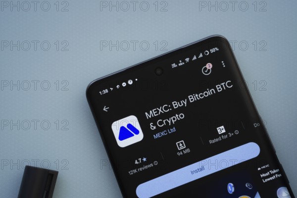 Dhaka, Bangladesh- 29 May 2025: On a blue surface, a smartphone displays the MEXC app within the