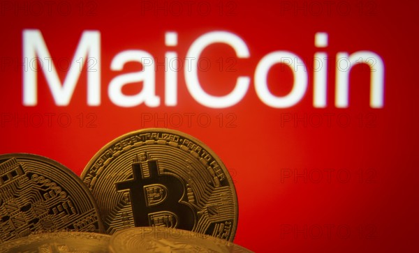 Dhaka, Bangladesh- 03 Sep 2025: Close-up of Bitcoin coins with the MaiCoin logo visible on a screen