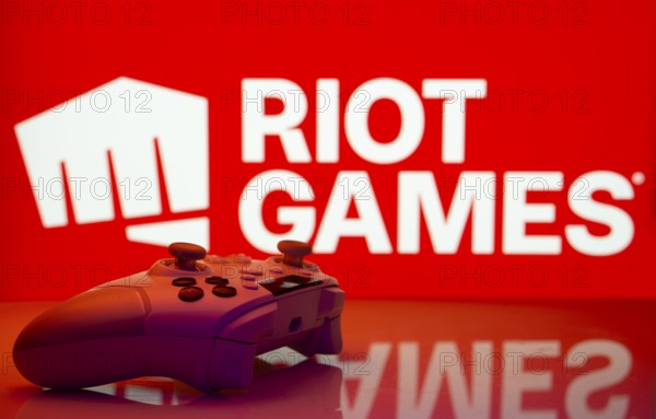 Dhaka, Bangladesh- 14 Nov 2025: A close-up of a white gamepad with the Riot Games seen on screen in