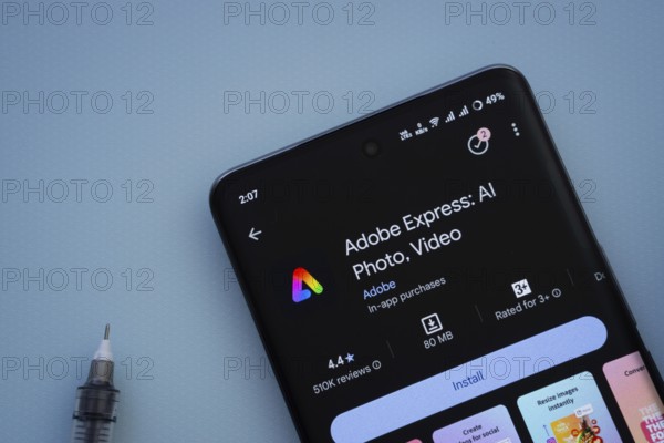 Dhaka, Bangladesh- 29 May 2025: On a blue surface, a smartphone displays the Adobe Express app