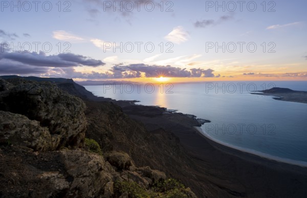 View from steep cliffs to sea and coast with sun stars, Mirador del Porrito viewpoint at sunset,