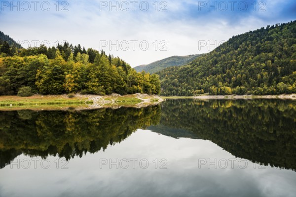 Picturesque mountain lake with water reflections in autumn, Lac de Kruth-Wildenstein, Kruth,