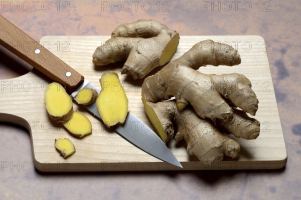 Ginger, ginger root cut with ginger slices on wooden boards