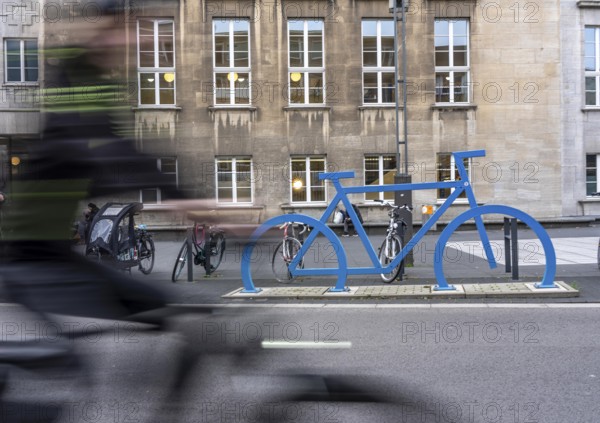Bicycle parking spaces, with so-called leaning bars and a large blue bicycle silhouette, to make