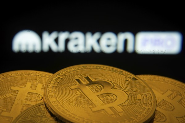 Dhaka, Bangladesh- 01 Nov 2025: Close-up of Bitcoin coins with the Kraken Pro logo visible on a