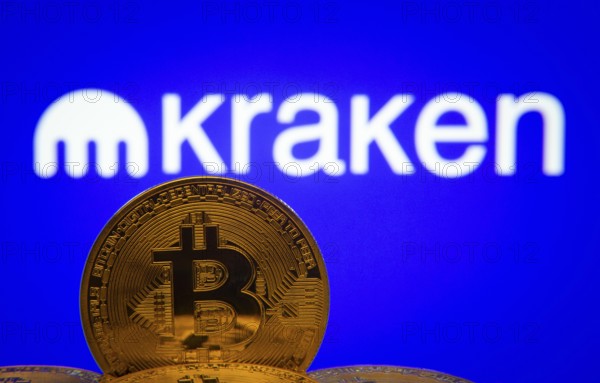 Dhaka, Bangladesh- 01 Nov 2025: Close-up of Bitcoin coins with the Kraken logo visible on a screen