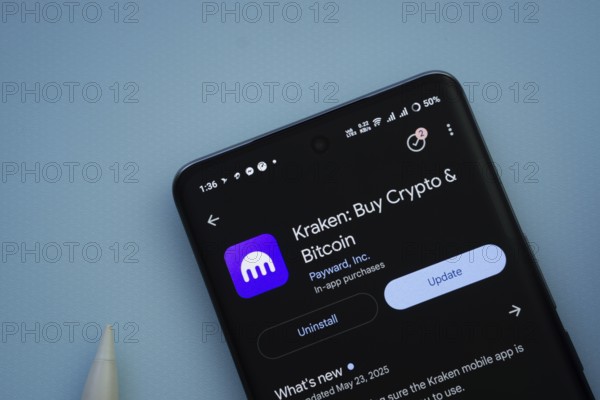 Dhaka, Bangladesh- 29 May 2025: On a blue surface, a smartphone displays the Kraken app within the