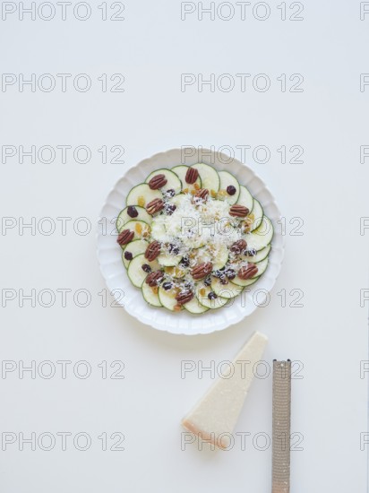 Delicious zucchini carpaccio with parmesan cheese, pecan nuts, raisins and cranberries served on