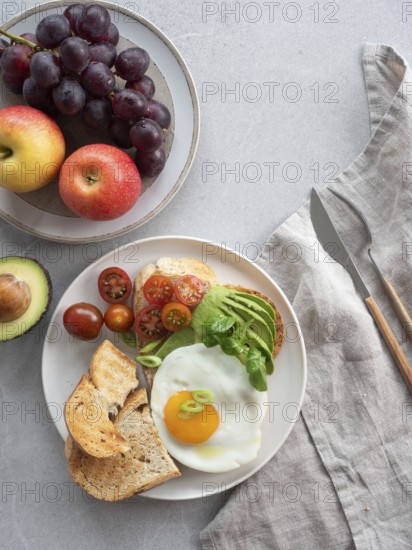 Enjoying a nutritious and delicious breakfast with whole wheat toast topped with avocado, a fried