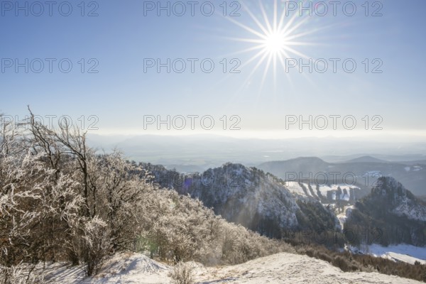 View over the hills and valleys from the mountain with hoarfrost on the branches in winter, Vápec,
