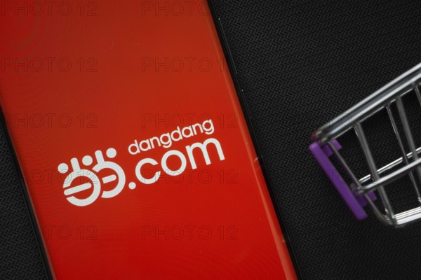 Dhaka, Bangladesh- 03 Oct 2025: A smartphone displaying the Dangdang.com logo next to a miniature