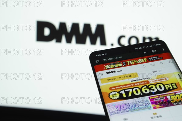 Dhaka, Bangladesh- 03 Oct 2025: Smartphone displaying Dmm.com web interface against Dmm.com logo