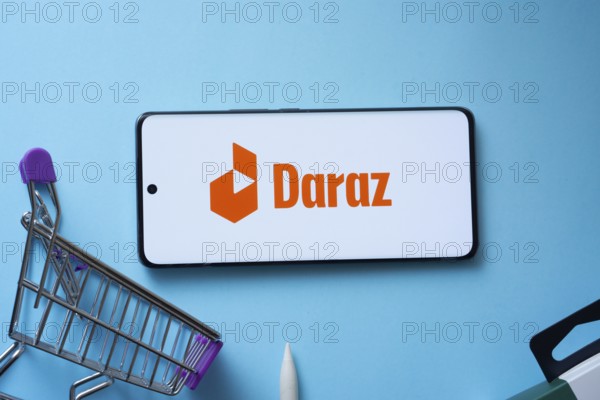 Dhaka, Bangladesh- 03 Oct 2025: Smartphone displaying Daraz logo with shopping cart on a blue