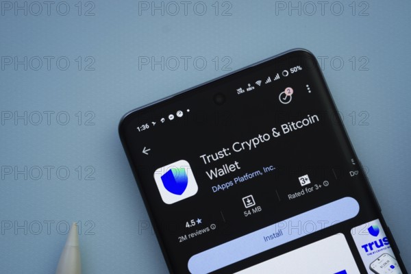 Dhaka, Bangladesh- 30 Sep 2025: On a blue surface, a smartphone displays the Trust Wallet app