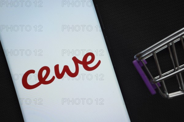 Dhaka, Bangladesh- 03 July 2025: A smartphone displaying the Cewe logo next to a miniature shopping