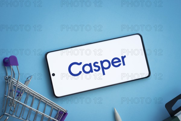 Dhaka, Bangladesh- 03 July 2025: Smartphone displaying Casper logo with shopping cart on a blue