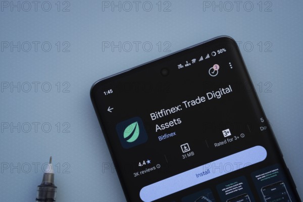 Dhaka, Bangladesh- 29 May 2025: On a blue surface, a smartphone displays the Bitfinex app within
