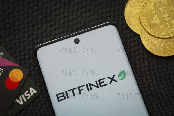 Dhaka, Bangladesh- 15 June 2025: Smartphone displaying Bitfinex logo surrounded by Bitcoin coins