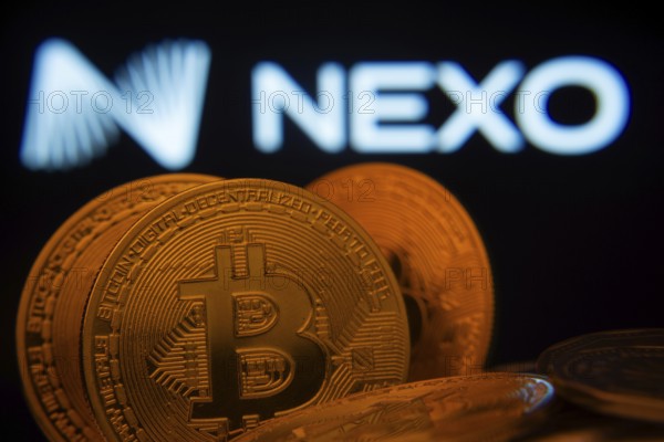 Dhaka, Bangladesh- 06 Sep 2025: Close-up of Bitcoin coins with the Nexo logo visible on a screen in