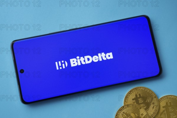 Dhaka, Bangladesh- 02 June 2025: BitDelta logo on smartphone screen near Bitcoin coin and QR code