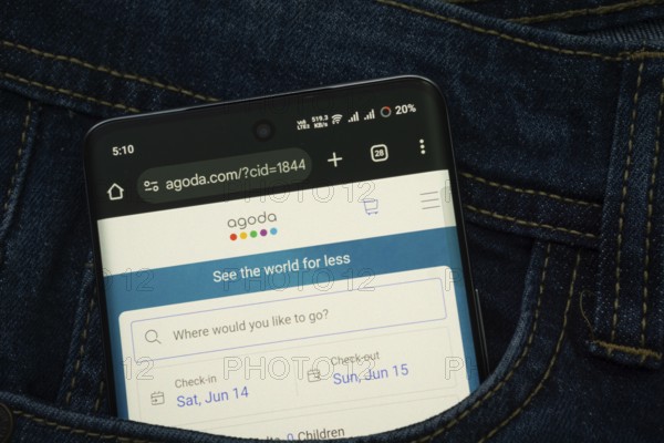 Dhaka, Bangladesh- 15 June 2025: A smartphone displaying the Agoda.com web interface peeks out of a
