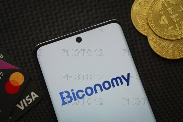 Dhaka, Bangladesh- 02 June 2025: Smartphone displaying Biconomy logo surrounded by Bitcoin coins