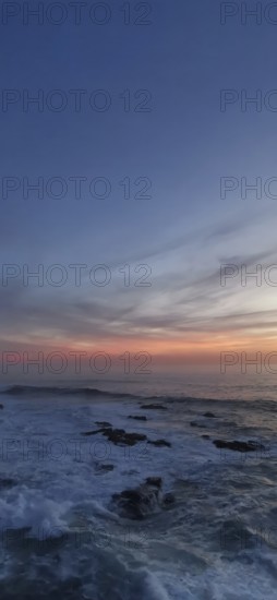 Sunset over a peaceful ocean with rocks in the foreground, hiking the Fisherman's trail, Rota