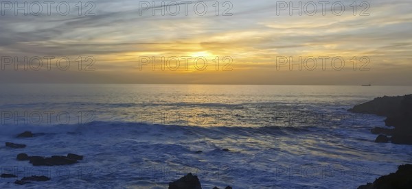 The sun sets over the ocean with visible waves, hiking the Fisherman's Trail, fishing trail, rota