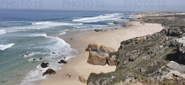 Rocky cliffs border an extensive sandy beach by the sea, hiking on the Fisherman's Trail, fishing