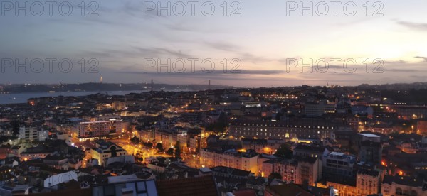Panoramic view of Lisbon, city view with illuminated streets and buildings under a twilight sky,