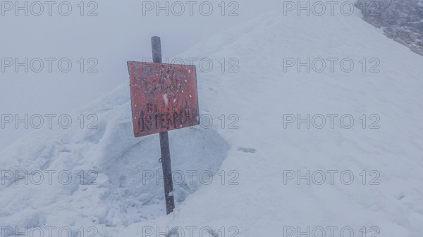Snow-covered landscape with a sign Republic of Austria, on the way to Zugspitze during snowstorm,