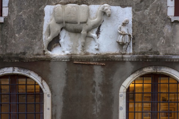 Historical relief with Moorish merchant and camel on the façade of a palazzo, Venice, Veneto, Italy
