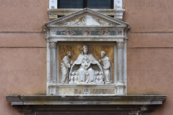 Sculpture of the Madonna of the Virgin Mary holding the faithful under her spread cloak, Madonna