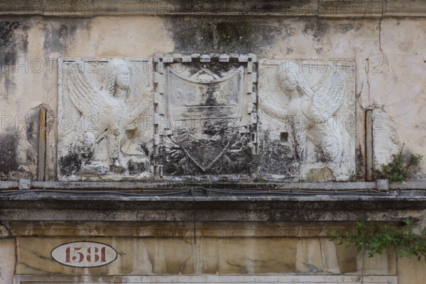 Relief over an entrance valley, two hybrid creatures, chimeras holding a coat of arms, Venice,