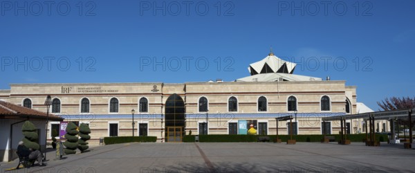 Long modern building with a flat roof and turquoise elements, Irfan Medeniyeti Arastirma ve Kültür
