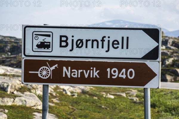 Signpost to Bjørnfjell railway station, railway line Kiruna-Narvik, and world war II memorial,