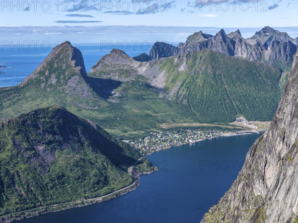 Aerial view from top of Mt. Grytetippen towards village Fjordgard, Mt. Segla and Mt. Hesten, Senja