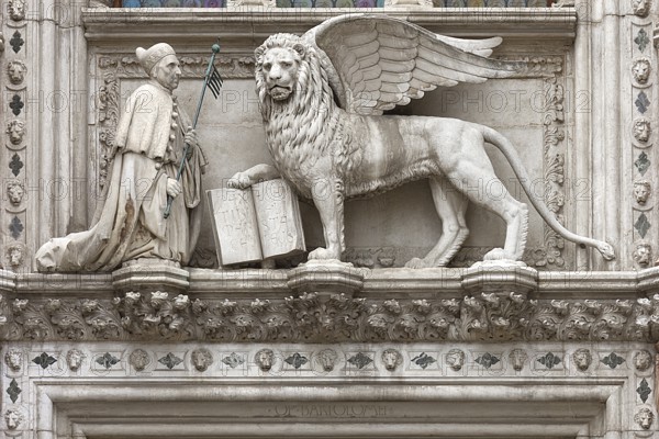 Doge kneels in front of St. Mark's Lion above the Porta della Carta of the Doge's Palace, Venice,