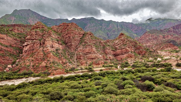 Wild, mountainous landscape with red rocks and thick clouds, The landscape and colorful rock