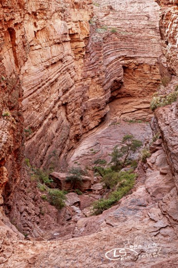 Impressive rock face with visible stratifications and limited vegetation, showing natural erosion,
