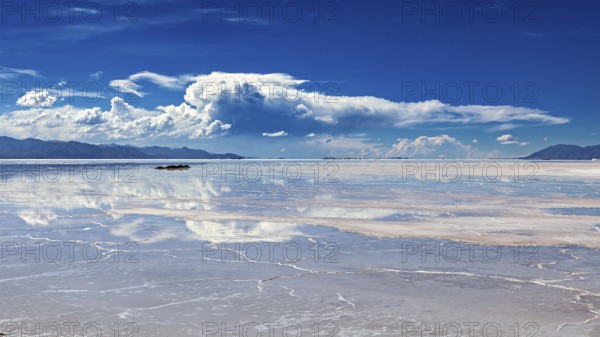 Wide view of a salt lake with cloud reflections in the water, The Salar de Cauchari salt pan near