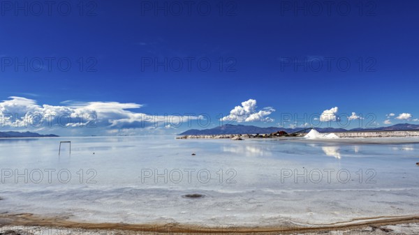 Wide view of a salt lake with blue sky and few clouds, The Salar de Cauchari salt pan near Salta in