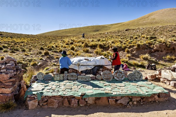 Archaeological excavation in the Andes with handicrafts and stones, surrounded by hills under blue