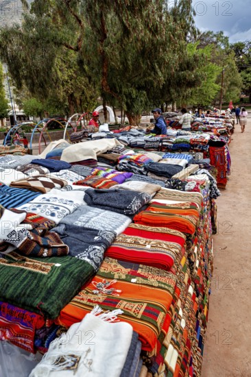 A stand with colorful textiles in a park-like setting, tourist and souvenir market of Santa Rosa de