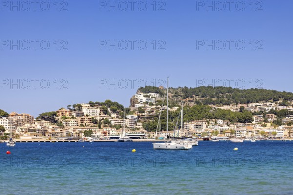 Scenic view of a coastal village with turquoise blue water and anchored sailboats and yachts and a
