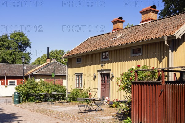 Picturesque Scandinavian courtyard featuring a traditional wooden building with garden furiture on
