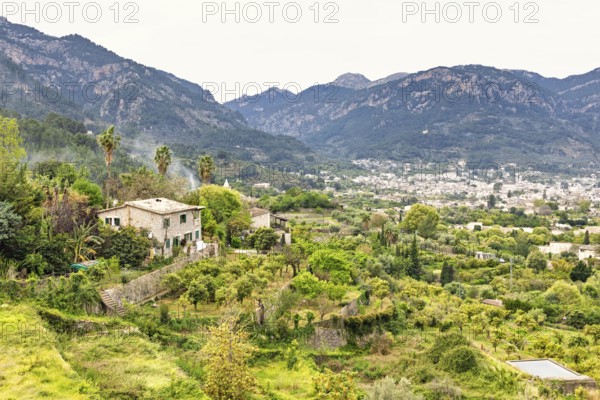 Serene rural landscape featuring a traditional stone house surrounded by vibrant greenery and